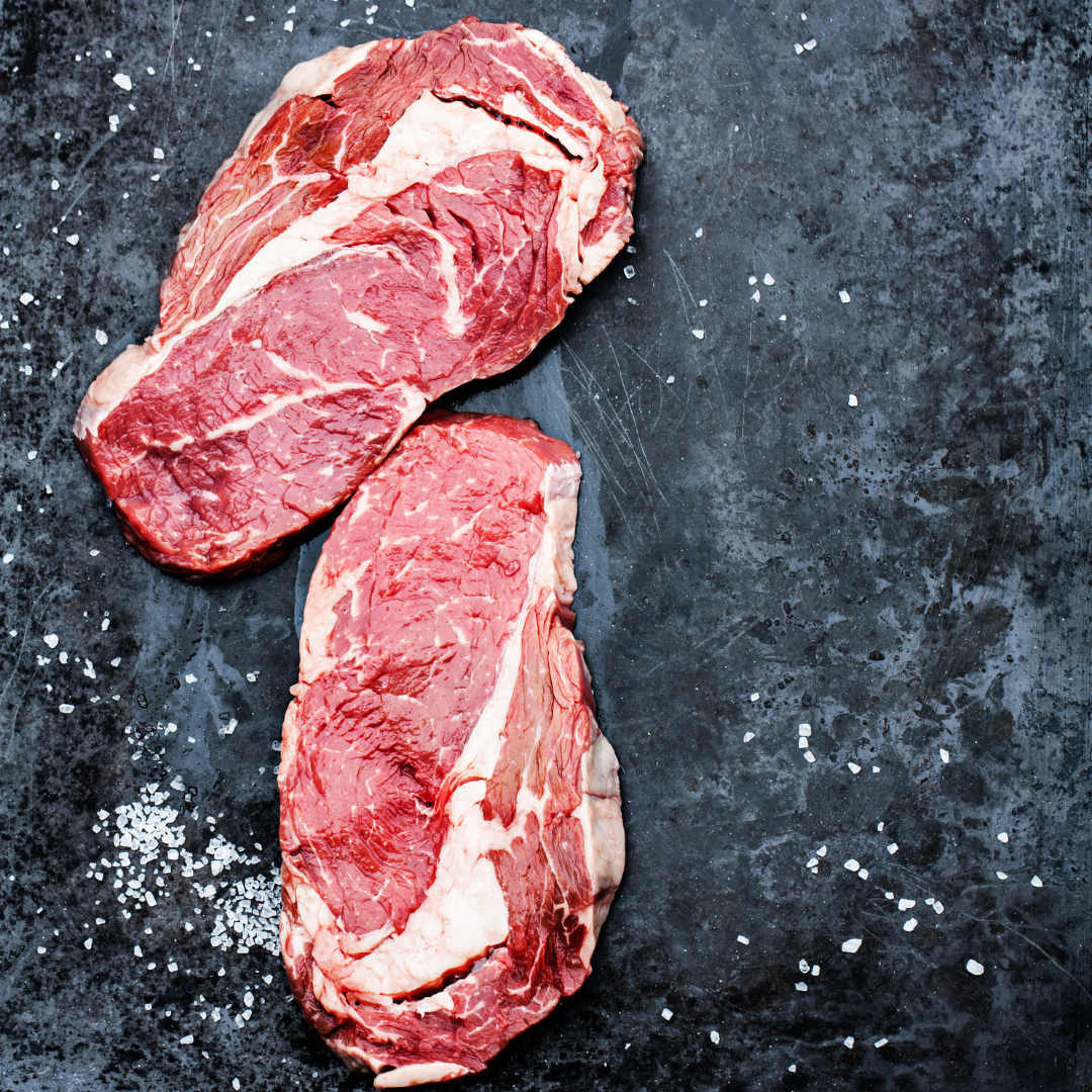 Raw sirloin steak on a slate cutting board.