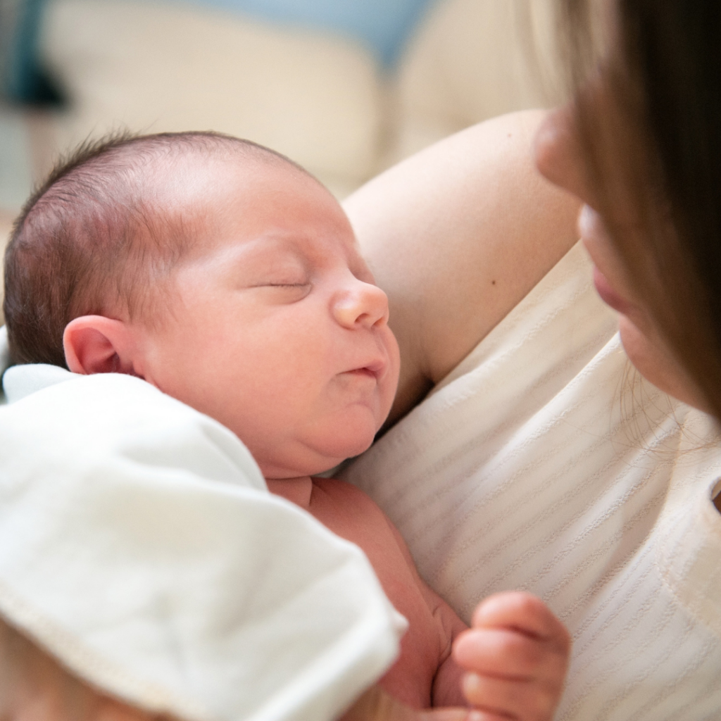 A mother cuddles their newborn.