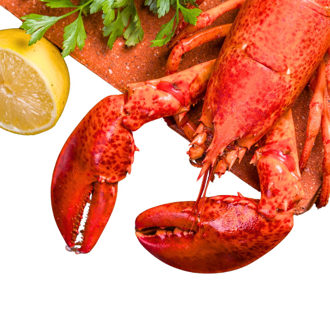 Bright red lobster on a cutting board with half a lemon beside it.