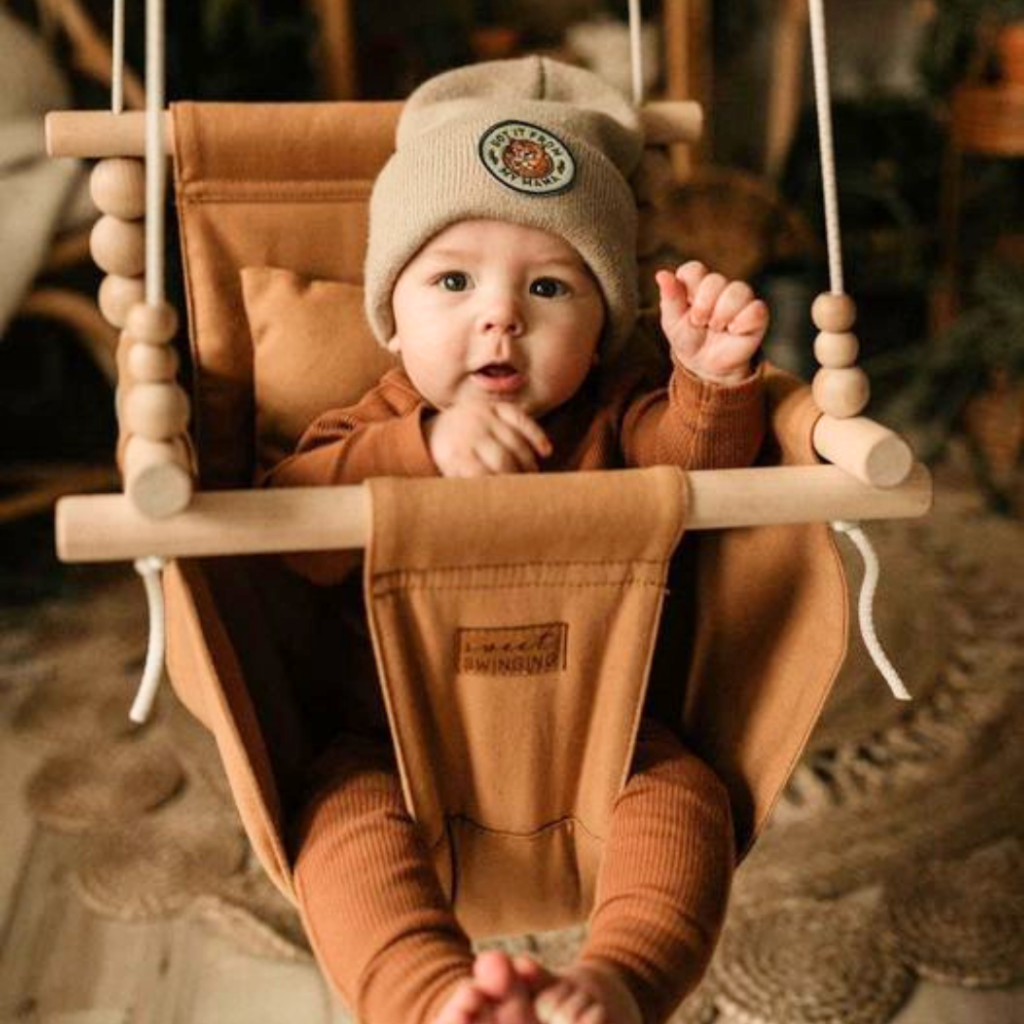 Baby in an indoor swing by Sweet Swinging as an ideal gift for babies.