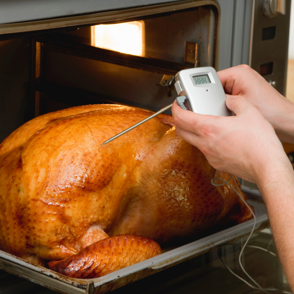 The internal temperature of a whole turkey in the oven is checked for safety to serve for baby led weaning.