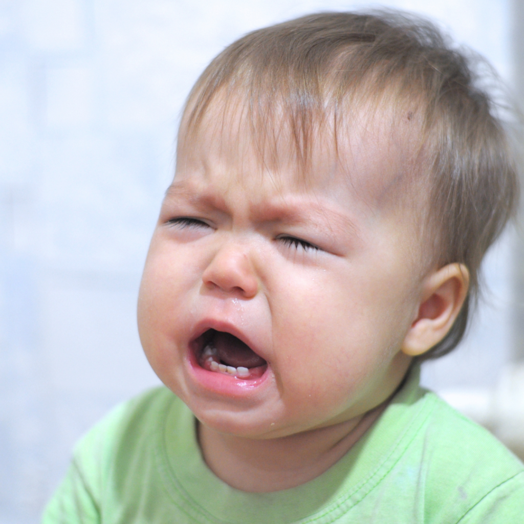 Baby with swollen eyes crying.