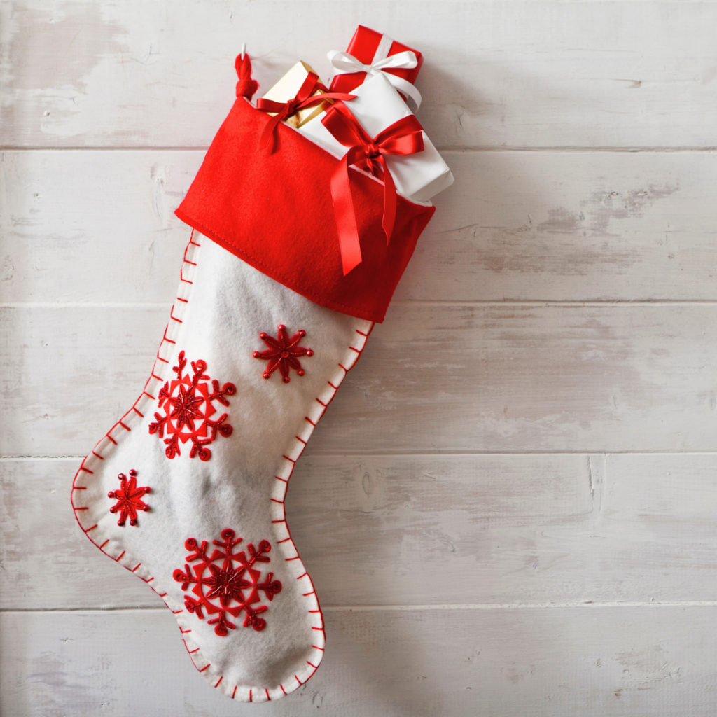 A red and white stocking filled with small gifts from holiday shopping.