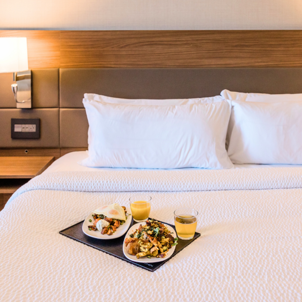 A bed in a hotel room with room service is a gift sure to impress moms.