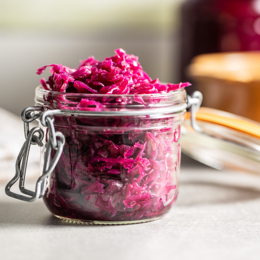 Cooked cabbage being stored in a glass jar for baby food.