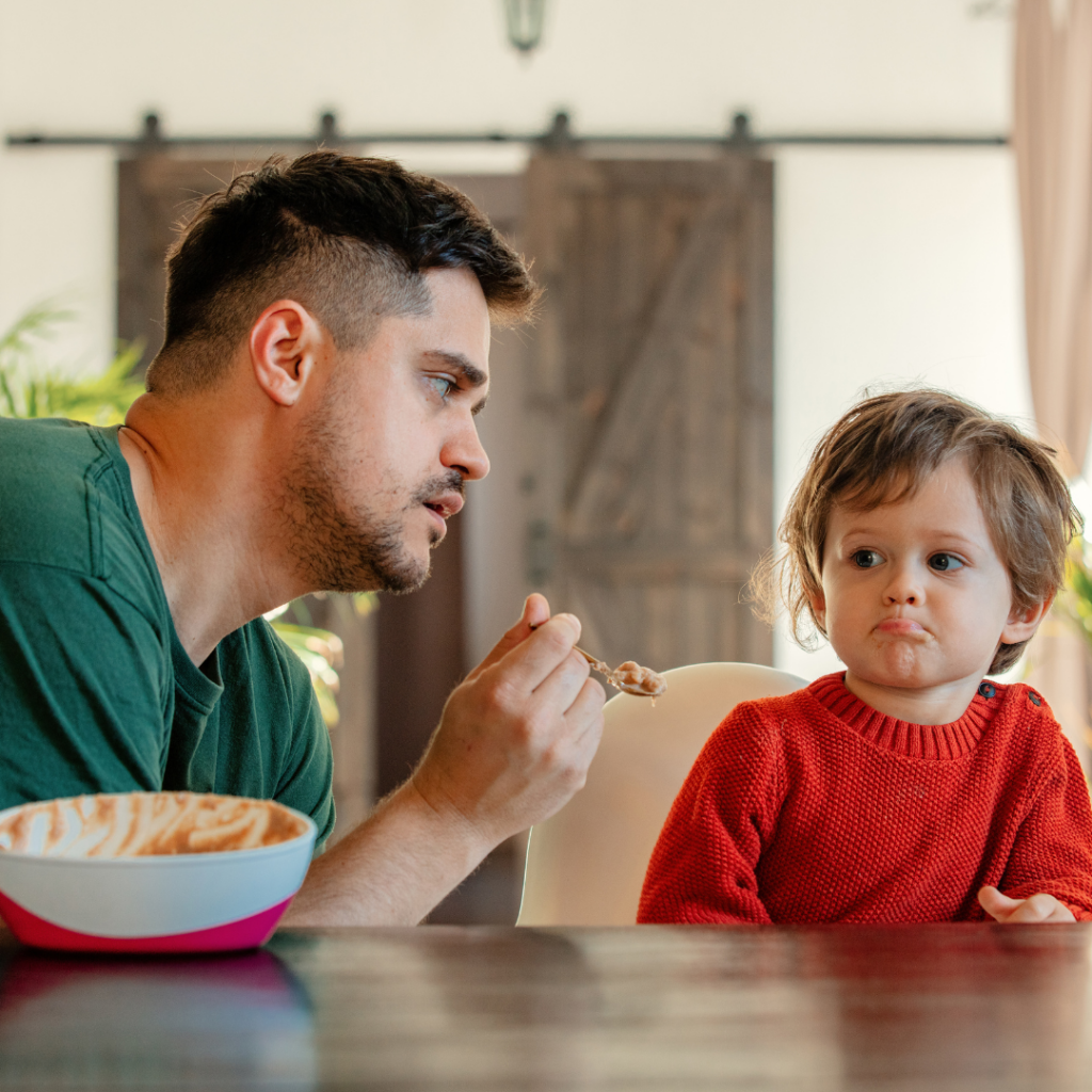 Parent pressuring their toddler to eat just one bite of their food.