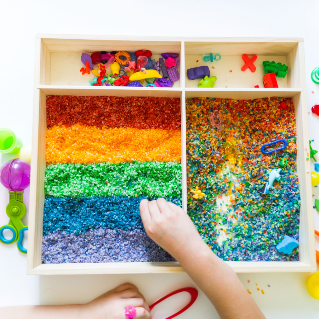 Sensory play station with beeds and colored rice to encourage the development of fine motor skills.