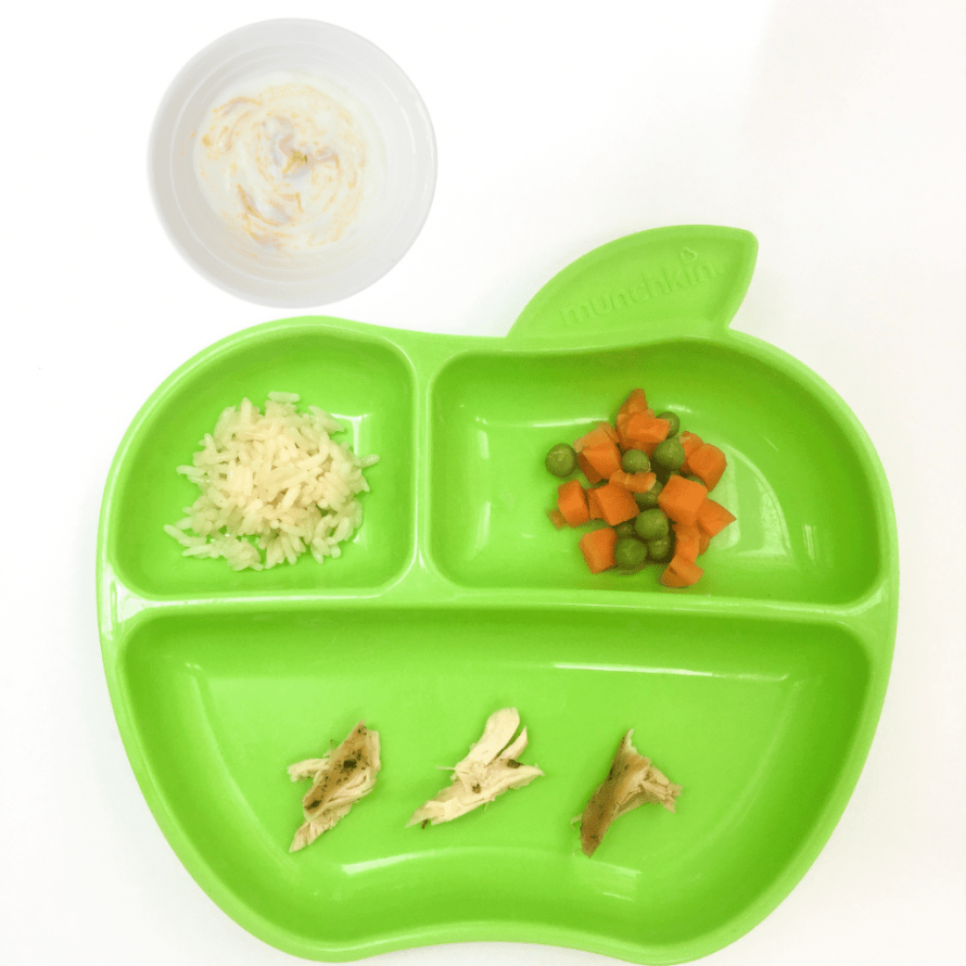 Starting solid foods with healthy eating habits by serving baby peas and carrots, cheese, chicken, and yogurt in baby-safe dishes.