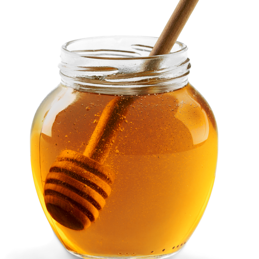 Honey in a glass jar with the honey dipper inside.