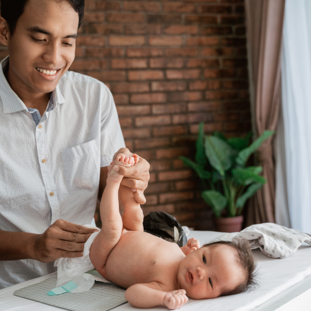 Dad changes a diaper after their baby's bowel movements.