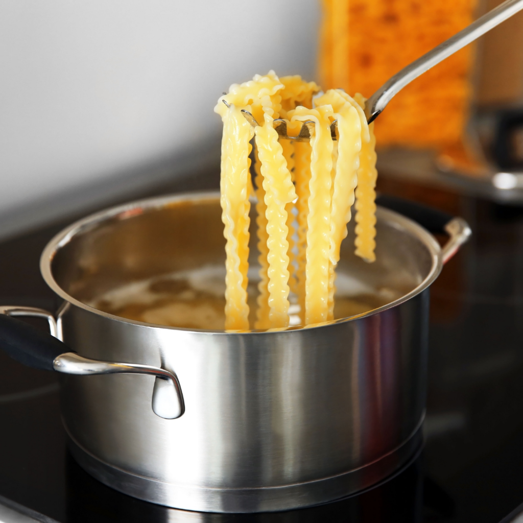 Cooking noodles al dente for introducing pasta to babies, and scooping some out of the pot on the stove.