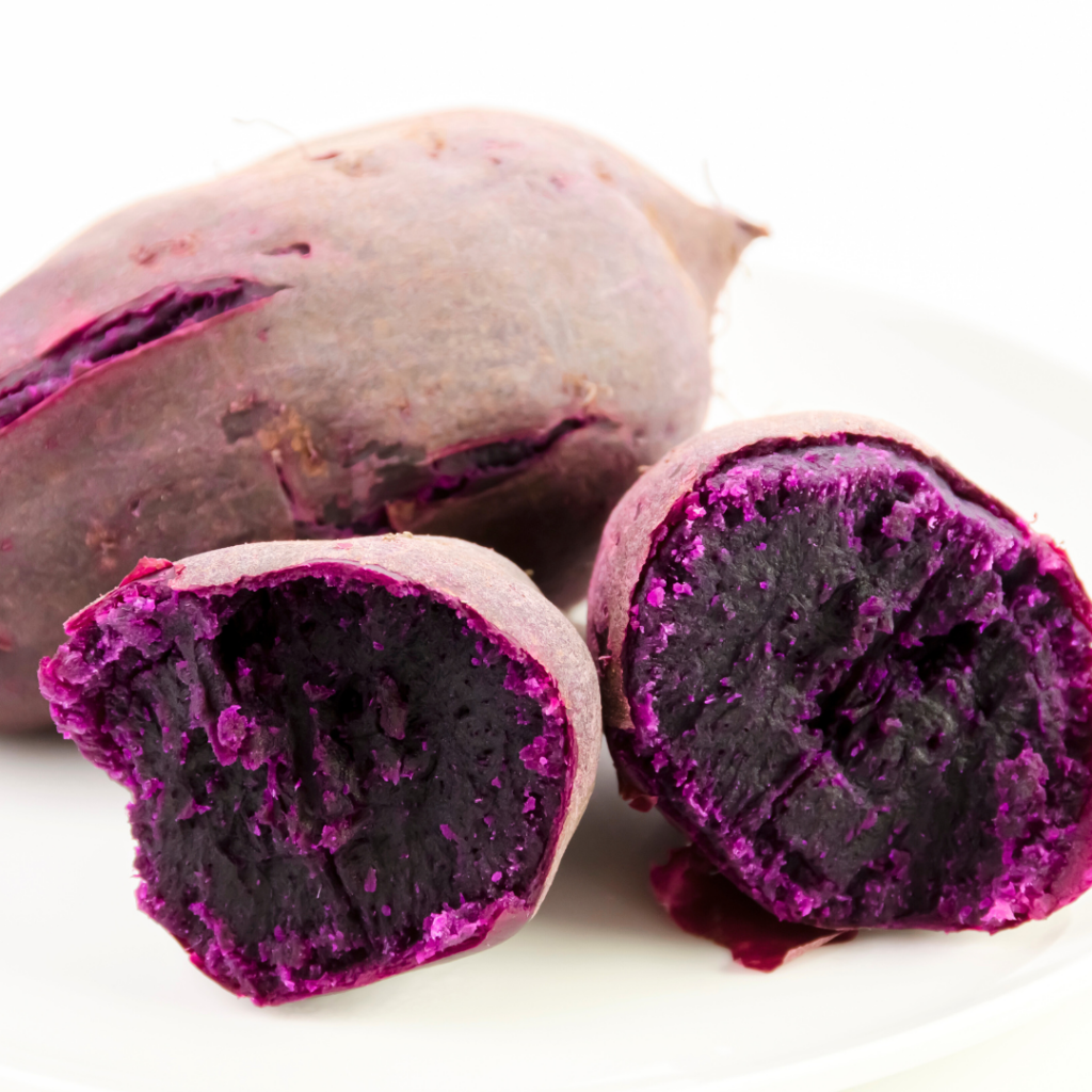 Two purple sweet potatoes, cooked, one cut in half to be used to make pureed sweet potatoes.