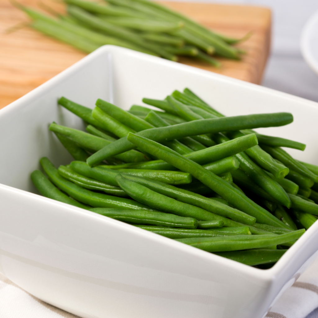 A white bowl of steamed green beans.