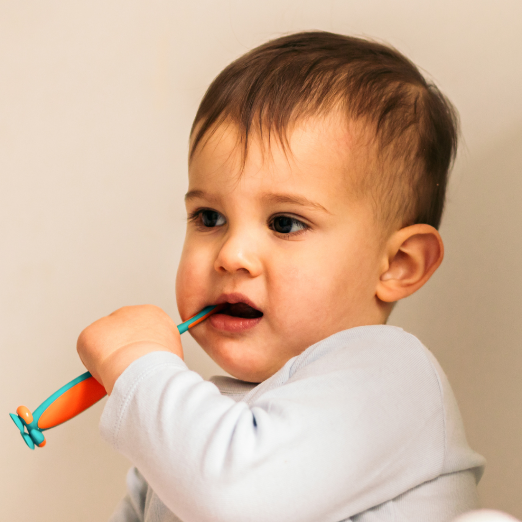 A baby chews on their toothbrush to help soothe sore gums.