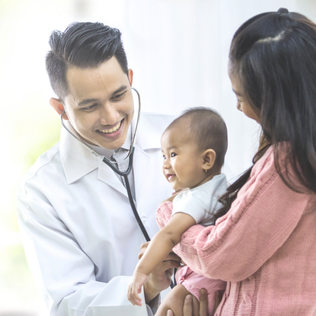 Baby being held by their mother while being examined by a doctor.