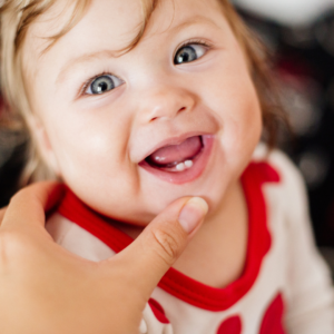 Baby smiling with two bottom teeth.