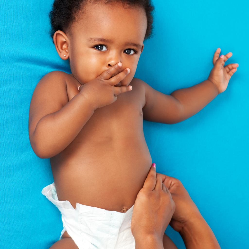 A baby lays down while having their diaper changed.