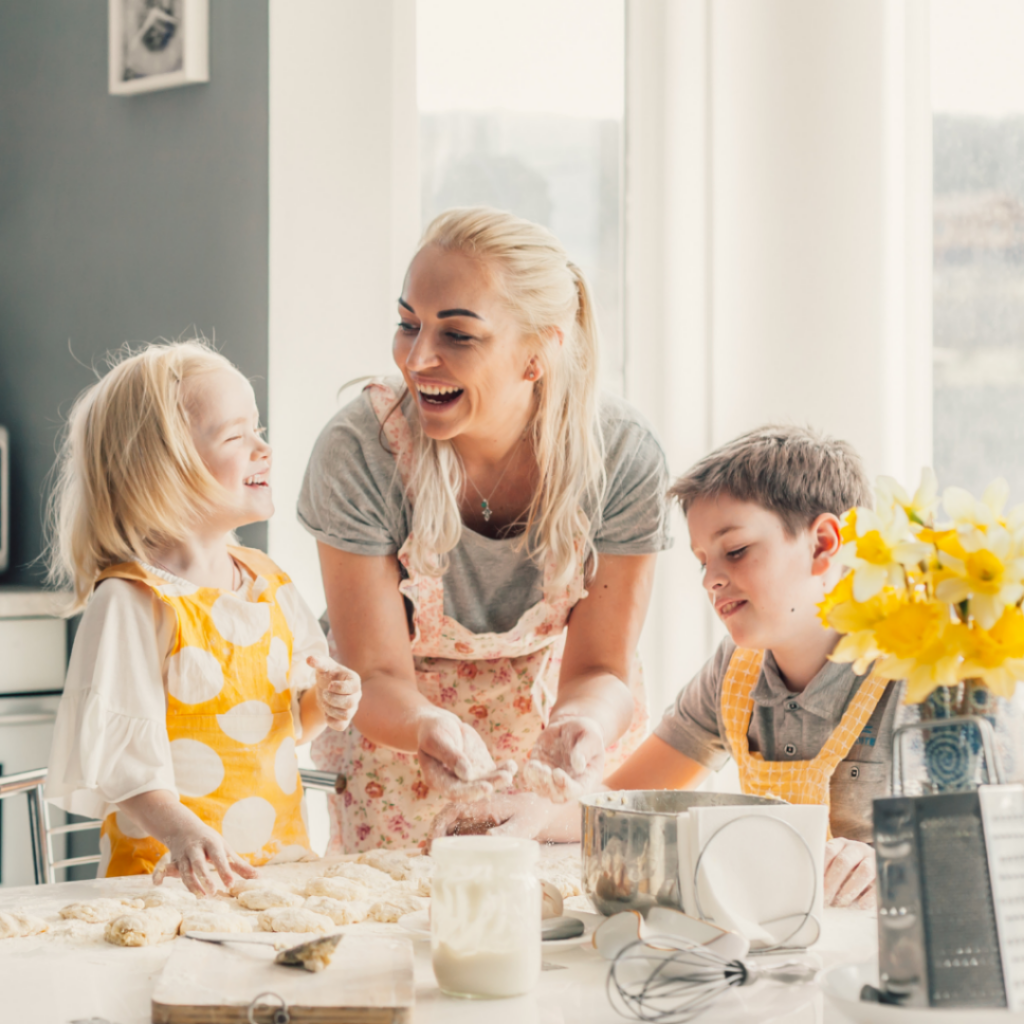 Two older kids cook or bake with their mom.