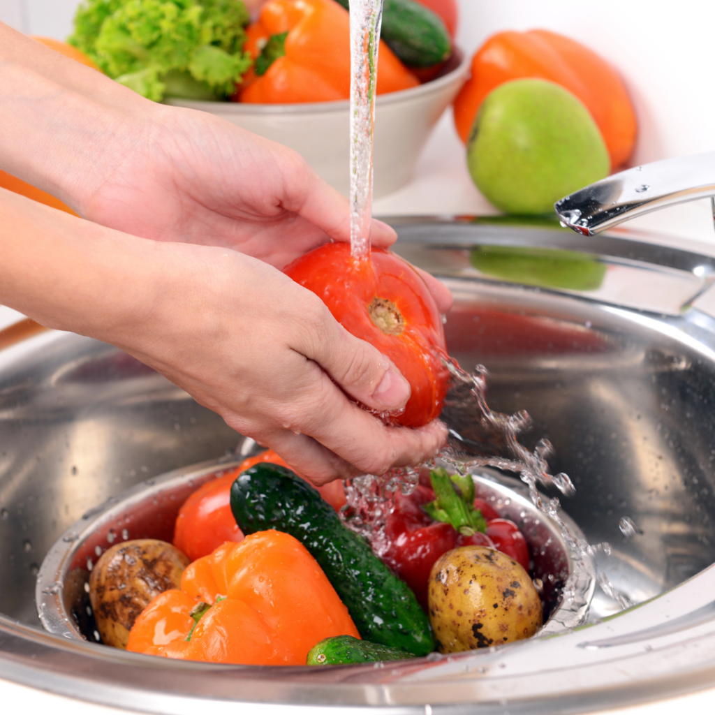 Washing fresh vegetables under running water in the sink to help remove heavy metals before baby eats them.