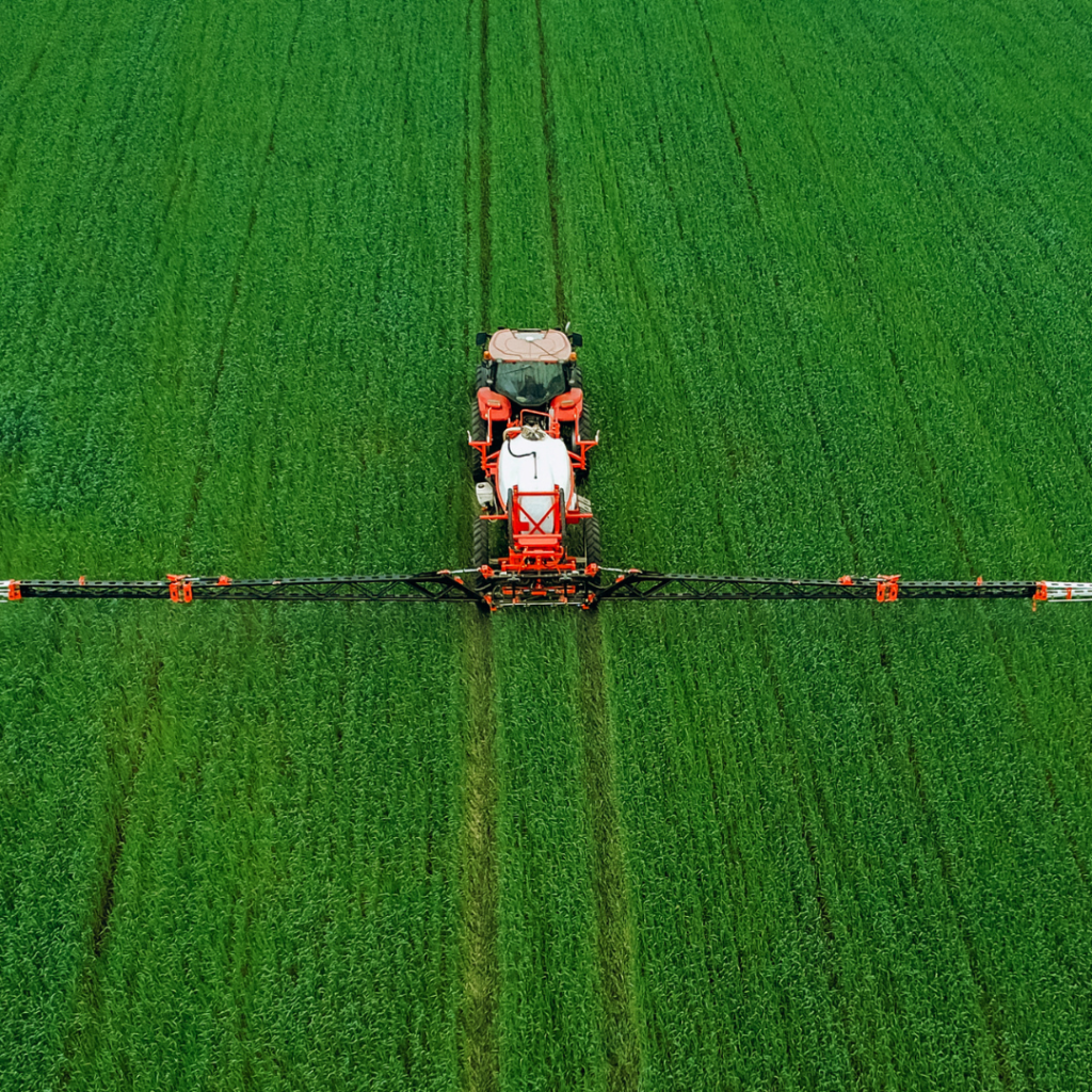 A tractor working in a field of crops.