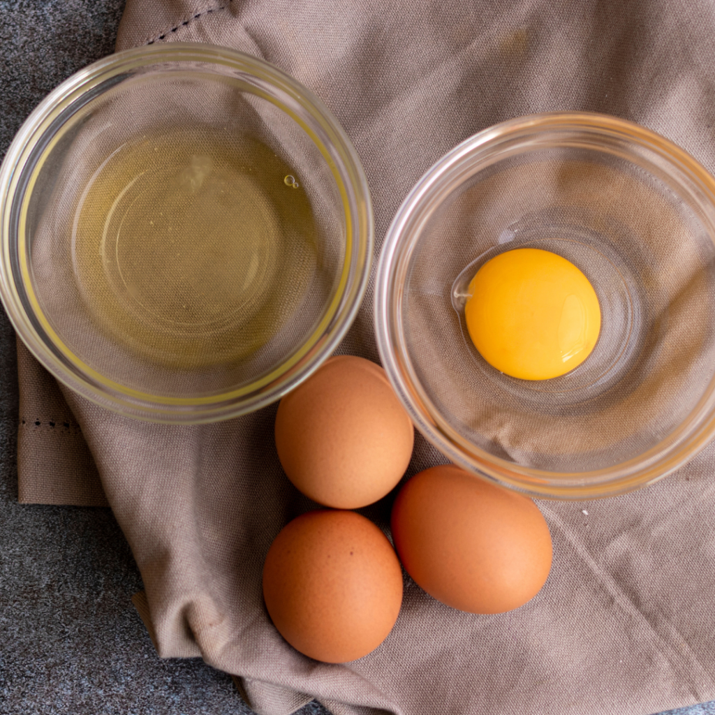 Egg white separated from the egg yolk, each in their own bowl, to be cooked for egg recipes.