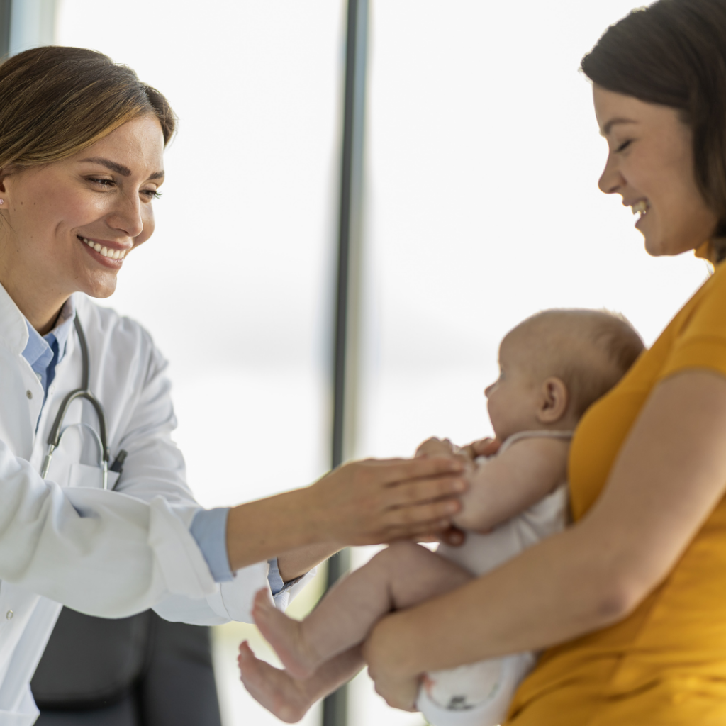 A doctor examining a baby while their parent holds them.