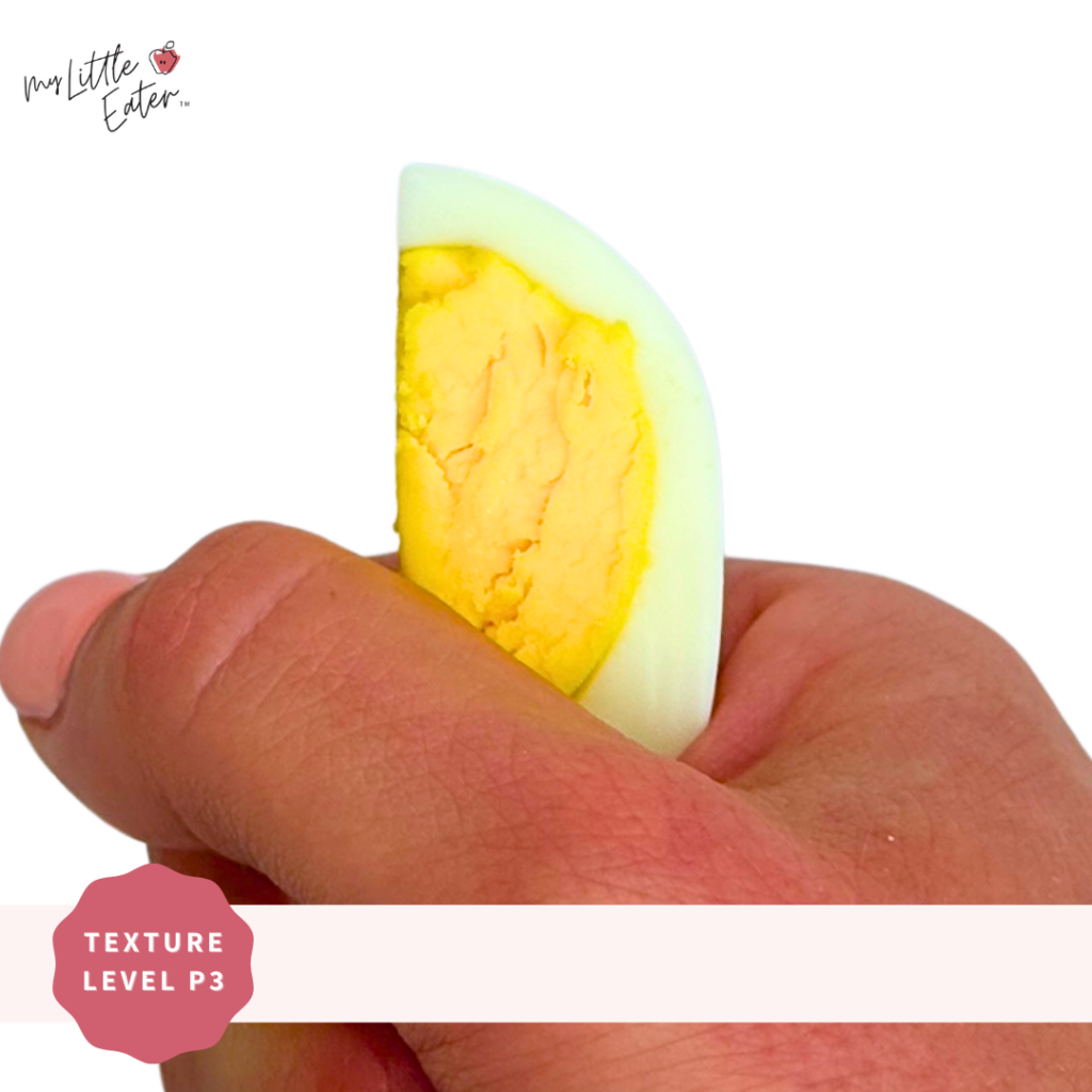 A hard-boiled egg sliced into a wedge being held in a palmar grasp.