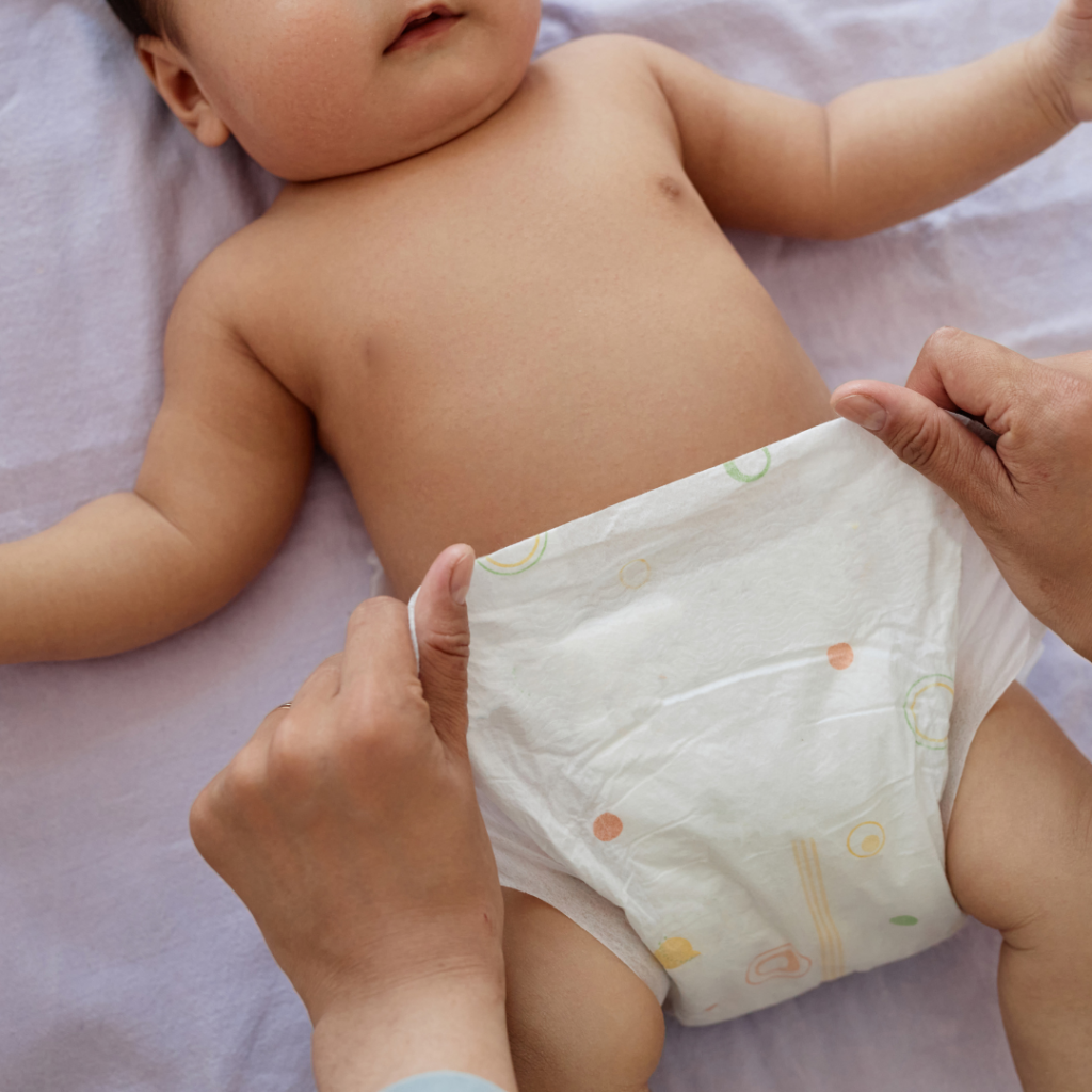 A parent changes a baby's diaper while inspecting for rashes after they start eating eggs.