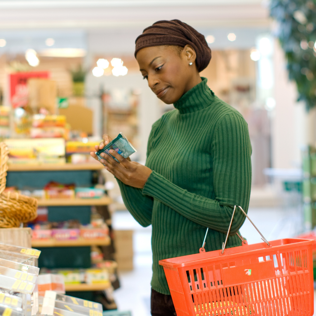 A mother reads a food label and assesses the ingredients at a grocery store to ensure no egg products are in packaged solid foods for babies.