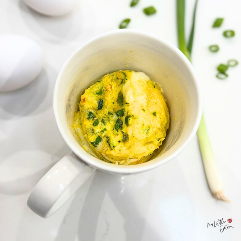 Egg muffins seasoned with green onions, cooked in a mug, for introducing eggs to babies with baby led weaning.