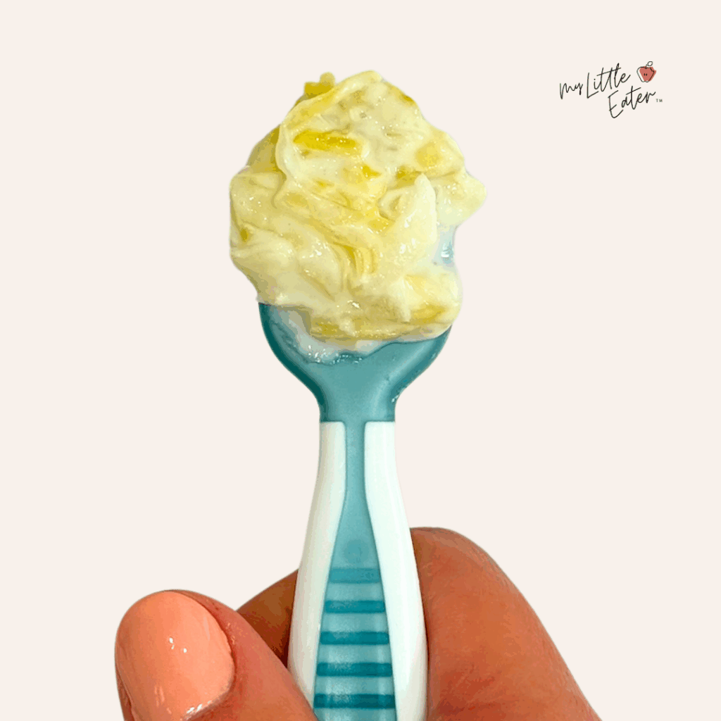 Sauerkraut mixed with yogurt on a blue numnum gootensil baby spoon.