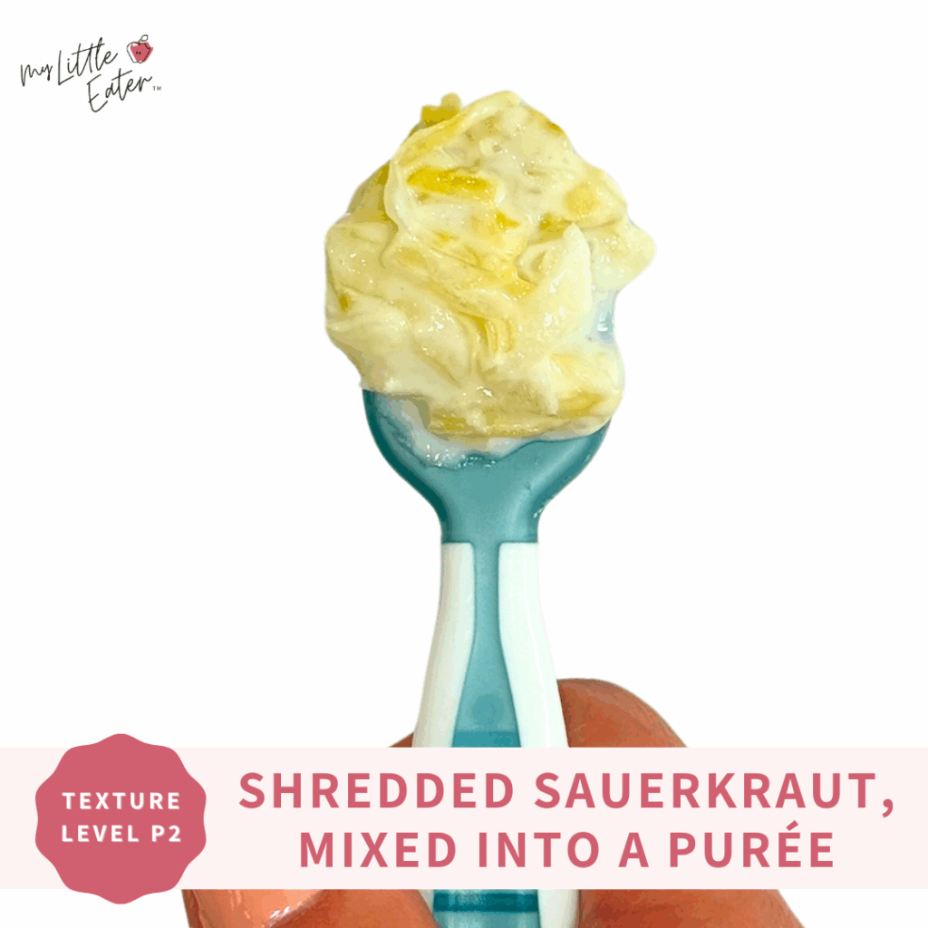 Shredded sauerkraut with a puree, like yogurt or hummus as a source of healthy fat, on a spoon to introduce sour flavors to babies.