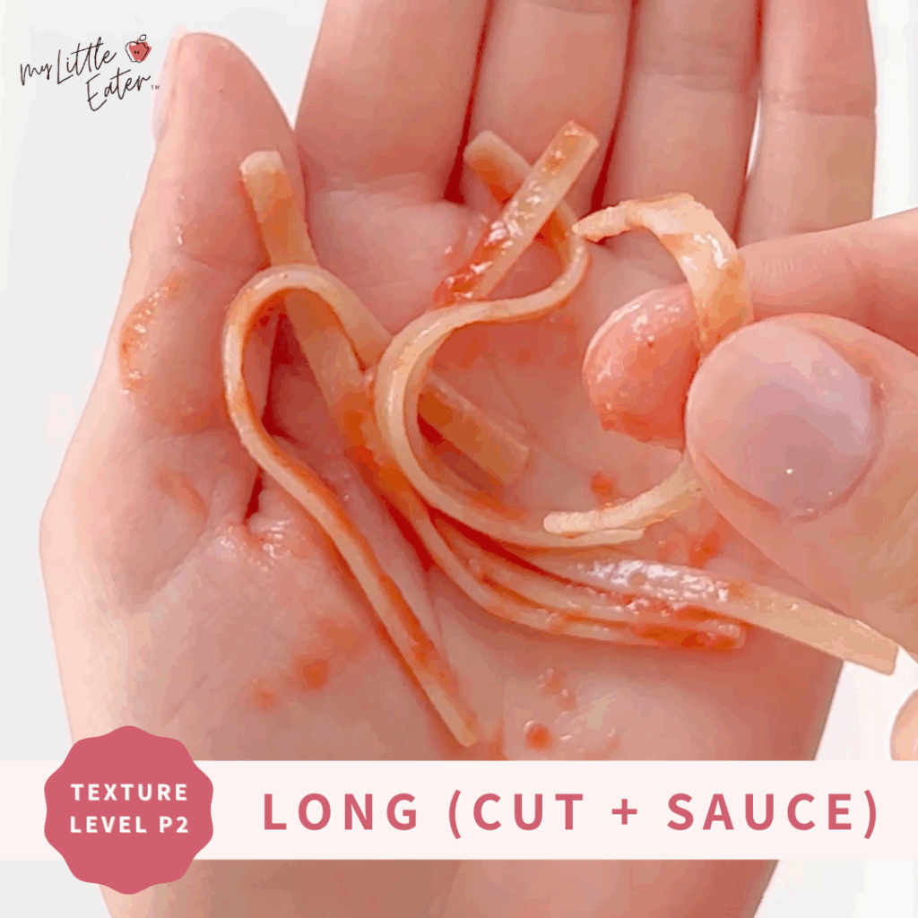Cut spaghetti noodles, with sauce, in someone's hand.