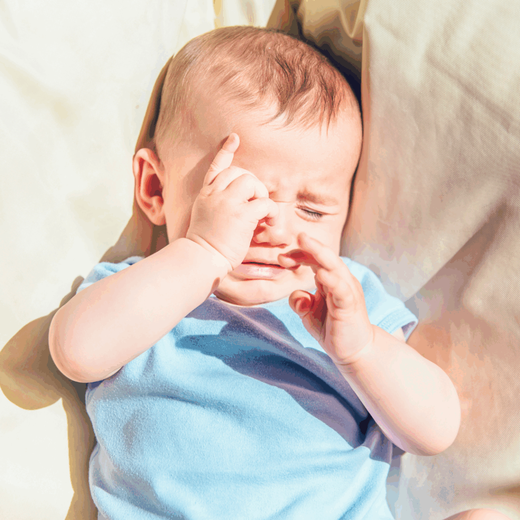 A baby looks fussy and is on the verge of tears