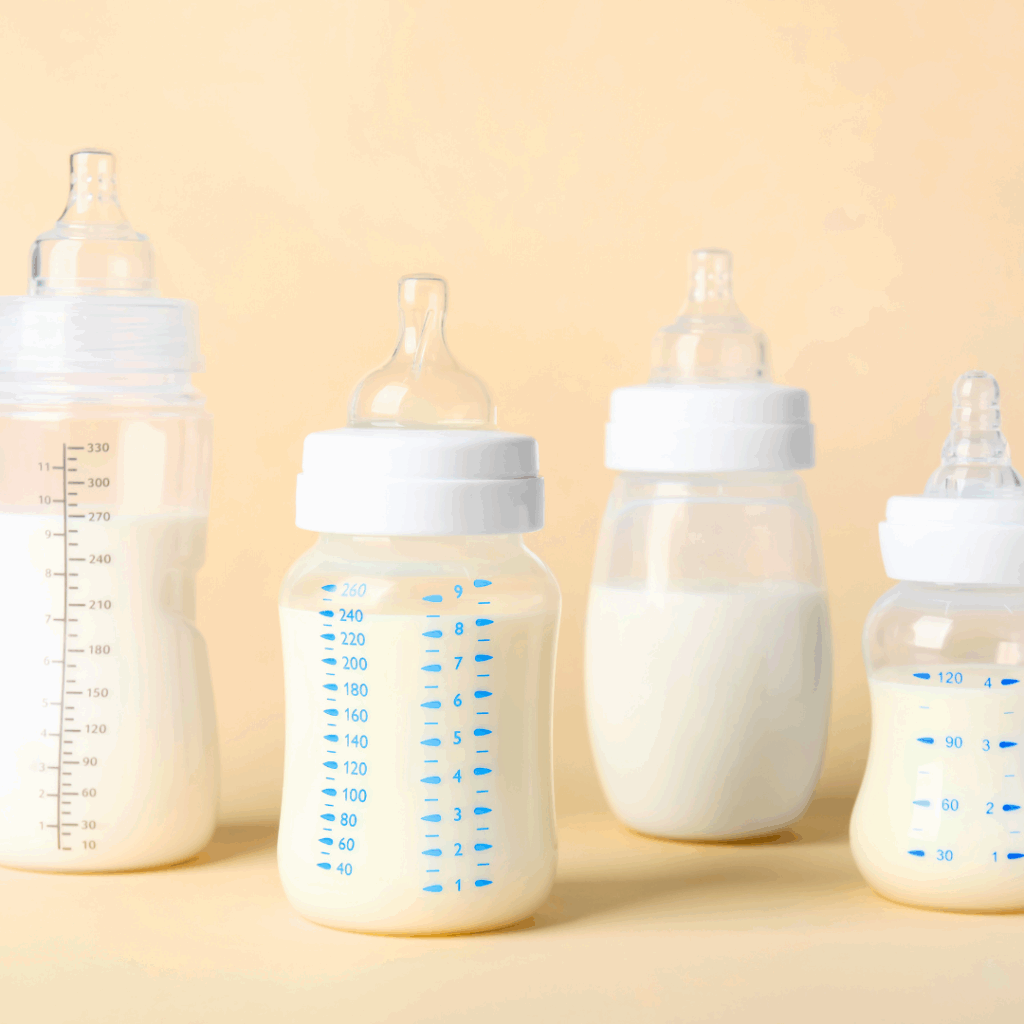 4 bottles placed side by side filled with various amounts of goat milk-based infant formula.