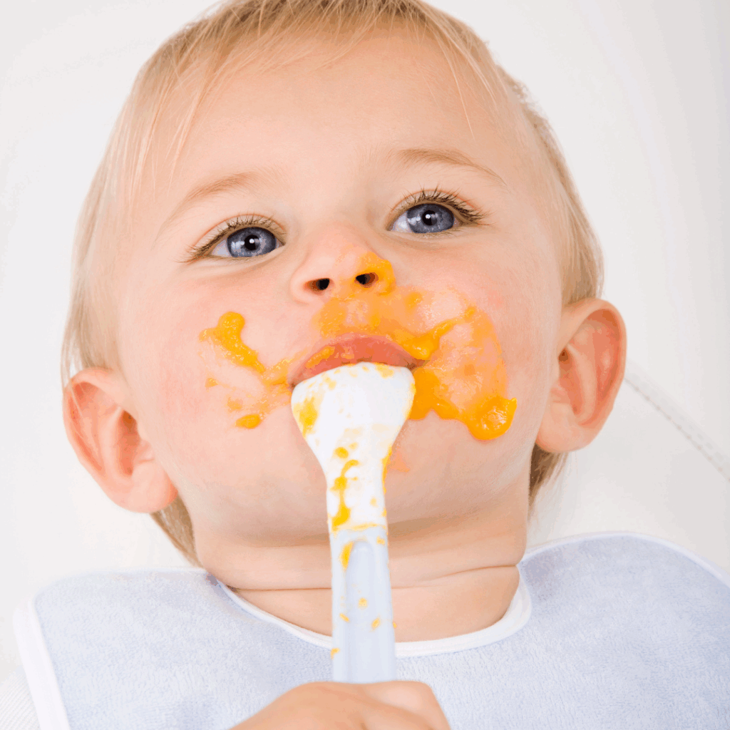 baby with messy mouth eating purees